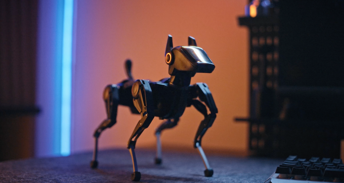Black Hengbot Sirius robot dog standing on a desk with blue and warm orange lighting.